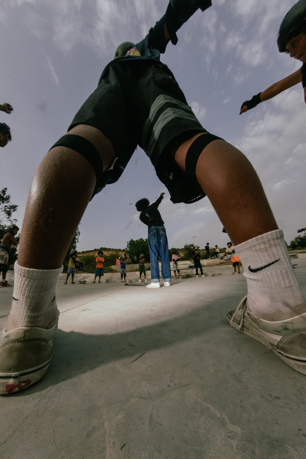 Low-angle view of a skater balancing while the rest of the group watches