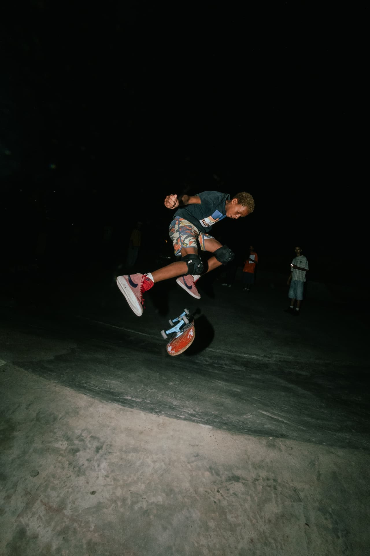 Young skater landing a kickflip during an evening session